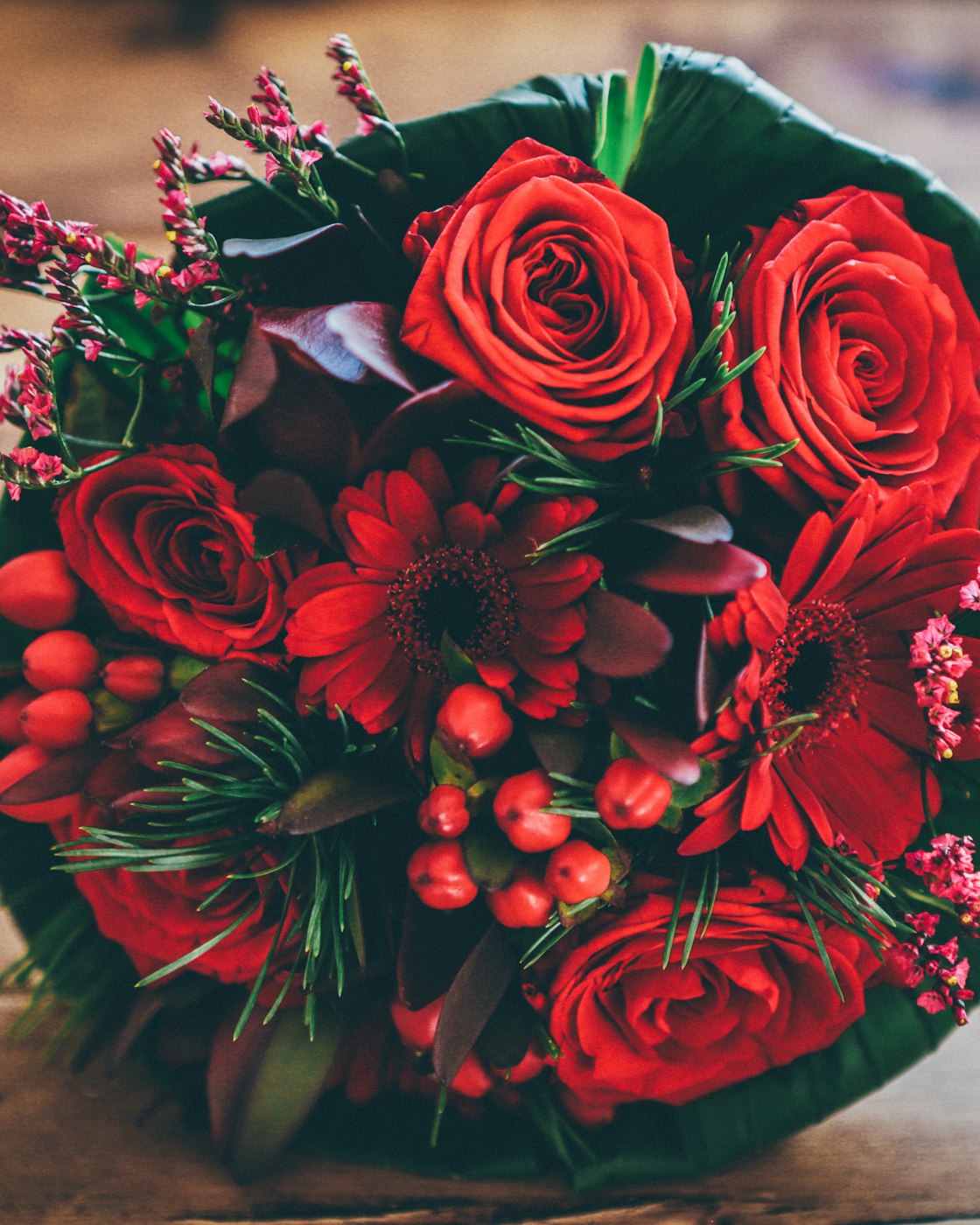Gebonden boeket met rode rozen, gerbera's en bessen